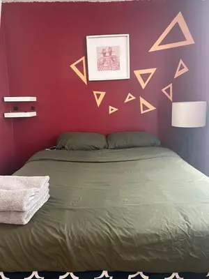 a bedroom with a bed with a red wall at Studio in Montreal downtown-Free WIFI-Beside metro station Guy-Concordia in Montréal