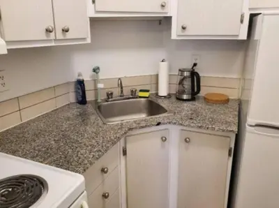 a kitchen counter with a sink and a refrigerator at Studio in Montreal downtown-Free WIFI-Beside metro station Guy-Concordia in Montréal