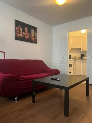 a living room with a red couch and a coffee table at Studio in Montreal downtown-Free WIFI-Beside metro station Guy-Concordia in Montréal