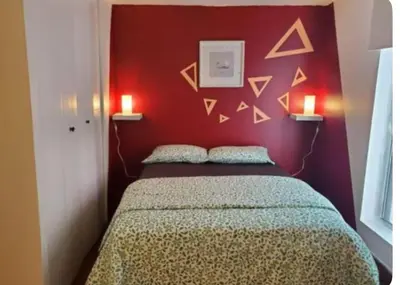 a bedroom with a bed with a red wall at Studio in Montreal downtown-Free WIFI-Beside metro station Guy-Concordia in Montréal