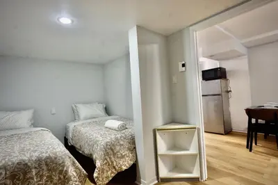 a small room with two beds and a table at Modern, cozy, near Metro, Place Bell, Free Parking in Laval
