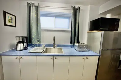 a kitchen counter with a sink and a window at Modern, cozy, near Metro, Place Bell, Free Parking in Laval