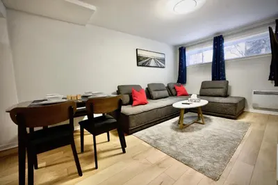 a living room with a couch and a table at Modern, cozy, near Metro, Place Bell, Free Parking in Laval