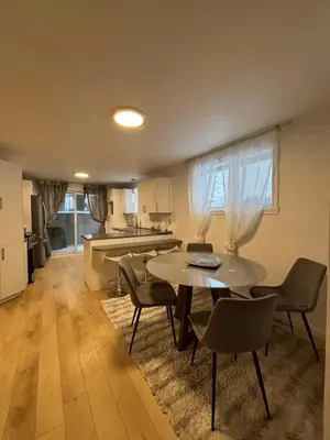 a living room with a table and chairs and a kitchen at Cozy fully-furnished appartement in St-Rose Laval in Laval