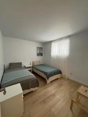 a bedroom with two beds and a wooden floor at Cozy fully-furnished appartement in St-Rose Laval in Laval