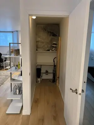 a hallway with a room with white walls and shelves at Cozy fully-furnished appartement in St-Rose Laval in Laval