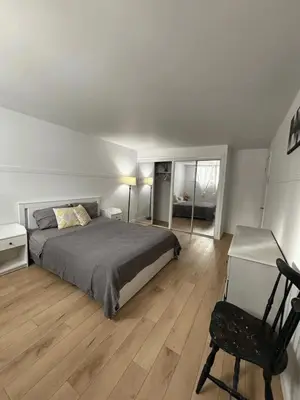 a bedroom with a bed and a chair and a desk at Cozy fully-furnished appartement in St-Rose Laval in Laval