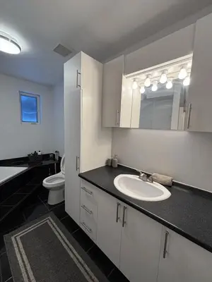 a bathroom with a sink and a toilet and a mirror at Cozy fully-furnished appartement in St-Rose Laval in Laval