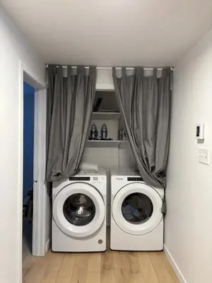 a laundry room with a washing machine and a washer at Cozy fully-furnished appartement in St-Rose Laval in Laval