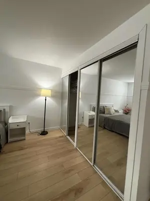 a living room with a bed and a mirror at Cozy fully-furnished appartement in St-Rose Laval in Laval