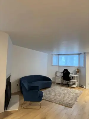 a living room with a blue couch and a chair at Cozy fully-furnished appartement in St-Rose Laval in Laval