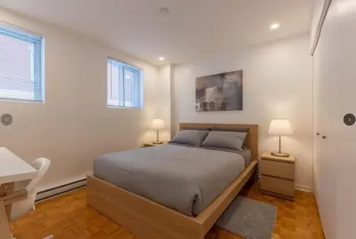 a bedroom with a bed and a desk and two lamps at Fully equiped flat, great location - ideal for relocation or short term mission in Montréal