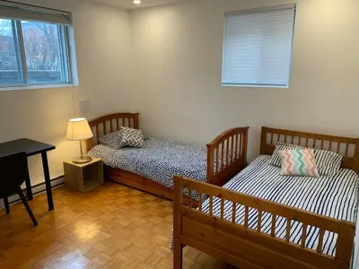 two beds in a room with a table and a desk at Fully equiped flat, great location - ideal for relocation or short term mission in Montréal