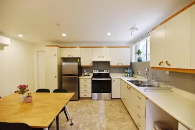 a kitchen with white cabinets and a wooden table at Fully equiped flat, great location - ideal for relocation or short term mission in Montréal