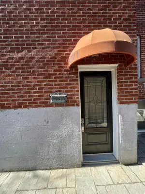 a door to a brick building with an awning over it at Fully equiped flat, great location - ideal for relocation or short term mission in Montréal