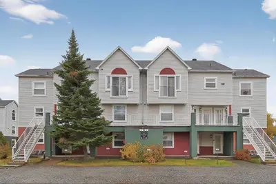 a large house with a tree in front of it at Condo ÉVASION in Magog-Orford
