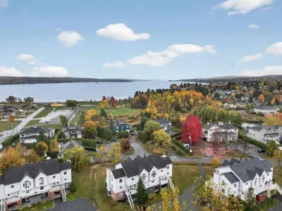 an aerial view of a town with houses and a lake at Condo ÉVASION in Magog-Orford