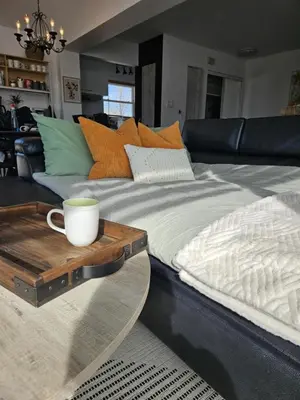a large bed with a coffee cup on a wooden tray at Condo ÉVASION in Magog-Orford
