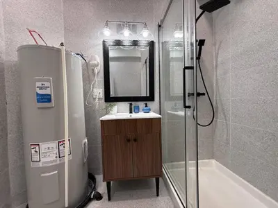 a bathroom with a shower and a sink and a mirror at Montreal's Downtown Glow & Go 2BR Apartment in Montréal