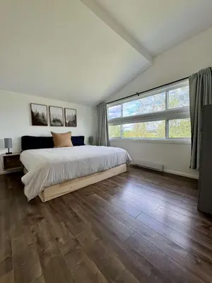 a bedroom with a large bed and a large window at Lake & Game Room - Chalet Brothers and Sun in Disraeli