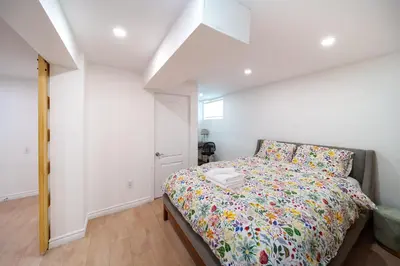 a bedroom with a bed with a colorful comforter at 4 beds entire house, 15 mins to MTL in Brossard