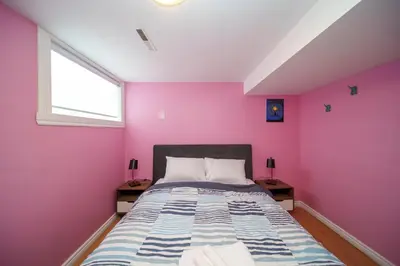 a bedroom with a pink wall and a bed at 4 beds entire house, 15 mins to MTL in Brossard