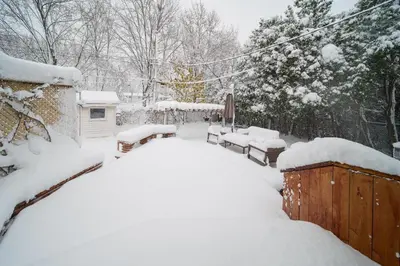 a yard covered in snow with benches and a house at 4 beds entire house, 15 mins to MTL in Brossard