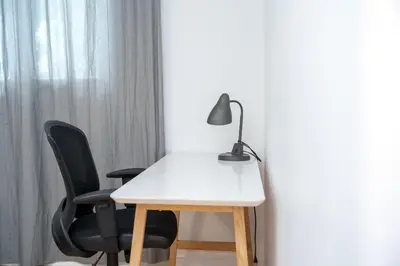 a white table with two chairs and a lamp at 4 beds entire house, 15 mins to MTL in Brossard