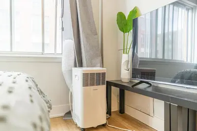 a room with a desk with a fan and a window at Studio in heart of DT,walk to 2 metros,Concordia in Montréal