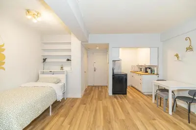 a room with two beds and a table and a kitchen at Studio in heart of DT,walk to 2 metros,Concordia in Montréal