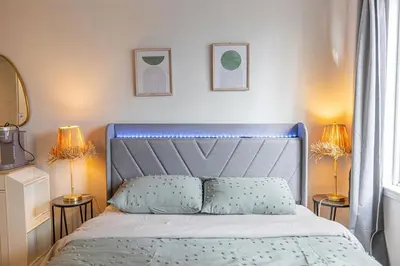 a bed with a blue headboard in a bedroom at Studio in heart of DT,walk to 2 metros,Concordia in Montréal