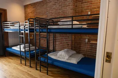 two bunk beds in a room with a brick wall at Auberge Le Treehouse in Montréal