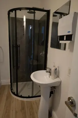 a bathroom with a shower and a sink at Auberge Le Treehouse in Montréal