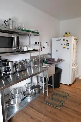a kitchen with stainless steel appliances and a white refrigerator at Auberge Le Treehouse in Montréal