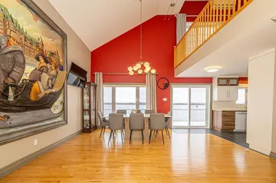 a dining room with a large painting on the wall at Unique Waterfront House 4 BDRs, Near MTL, Fishing in Laprairie