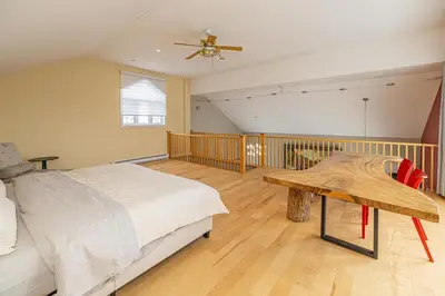 a bedroom with a bed and a ceiling fan at Unique Waterfront House 4 BDRs, Near MTL, Fishing in Laprairie