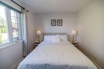 a white bed in a room with a window at Spacious 4BDRS Entire House near DT, Free Parking in Longueuil