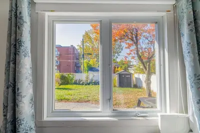 a window with a view of a yard at Spacious 4BDRS Entire House near DT, Free Parking in Longueuil