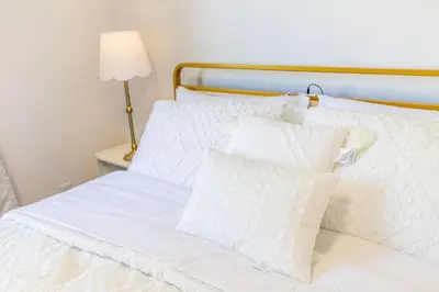 a white bed with white pillows and a lamp at Spacious 4BDRS Entire House near DT, Free Parking in Longueuil