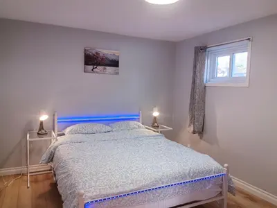 a bedroom with a bed and a window and two lamps at Entire NEW House 5BDR , close to DT MTL, 4 Parking in Brossard