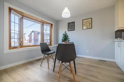 a kitchen with two chairs and a table with a christmas tree at Entire NEW House 5BDR , close to DT MTL, 4 Parking in Brossard