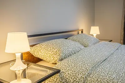 a bedroom with a bed and a table with a lamp at Entire NEW House 5BDR , close to DT MTL, 4 Parking in Brossard