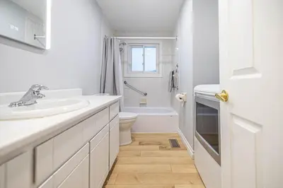 a white bathroom with a sink and a toilet at Entire NEW House 5BDR , close to DT MTL, 4 Parking in Brossard