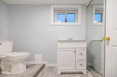 a white bathroom with a toilet and a sink at Entire NEW House 5BDR , close to DT MTL, 4 Parking in Brossard