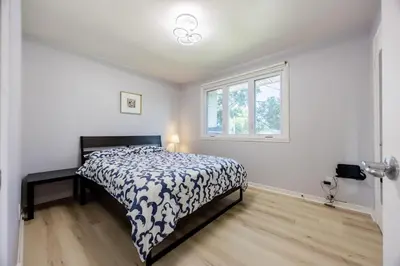 a bedroom with a bed and a window at Quiet 4 BR House , 20 min to DT, Free Parking in Brossard