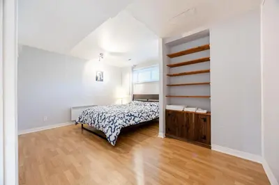 a bedroom with a bed and a wooden floor at Quiet 4 BR House , 20 min to DT, Free Parking in Brossard