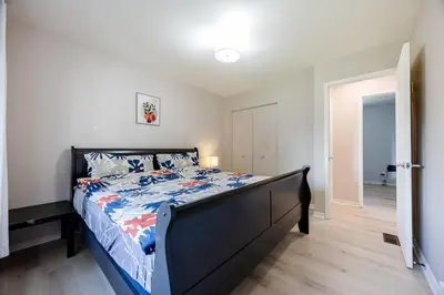 a bedroom with a bed with a blue comforter at Quiet 4 BR House , 20 min to DT, Free Parking in Brossard