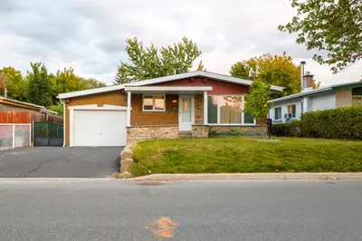 a brick house with a white garage at Autumn Fairy Tale, Comfy Entire House with parking in Brossard