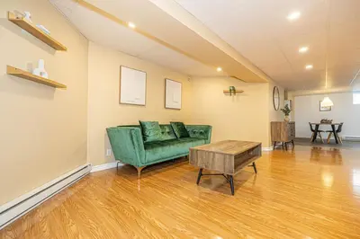 a living room with a green couch and a table at Spacious 2BDRs Apt,ALL NEW! Close to DT , 1 parking in Brossard