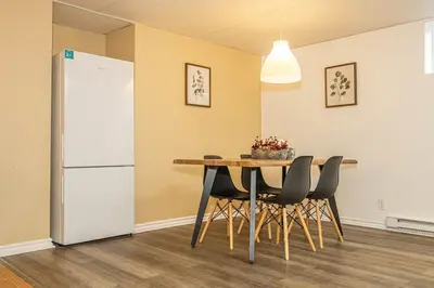 a dining room with a table and a refrigerator at Spacious 2BDRs Apt,ALL NEW! Close to DT , 1 parking in Brossard
